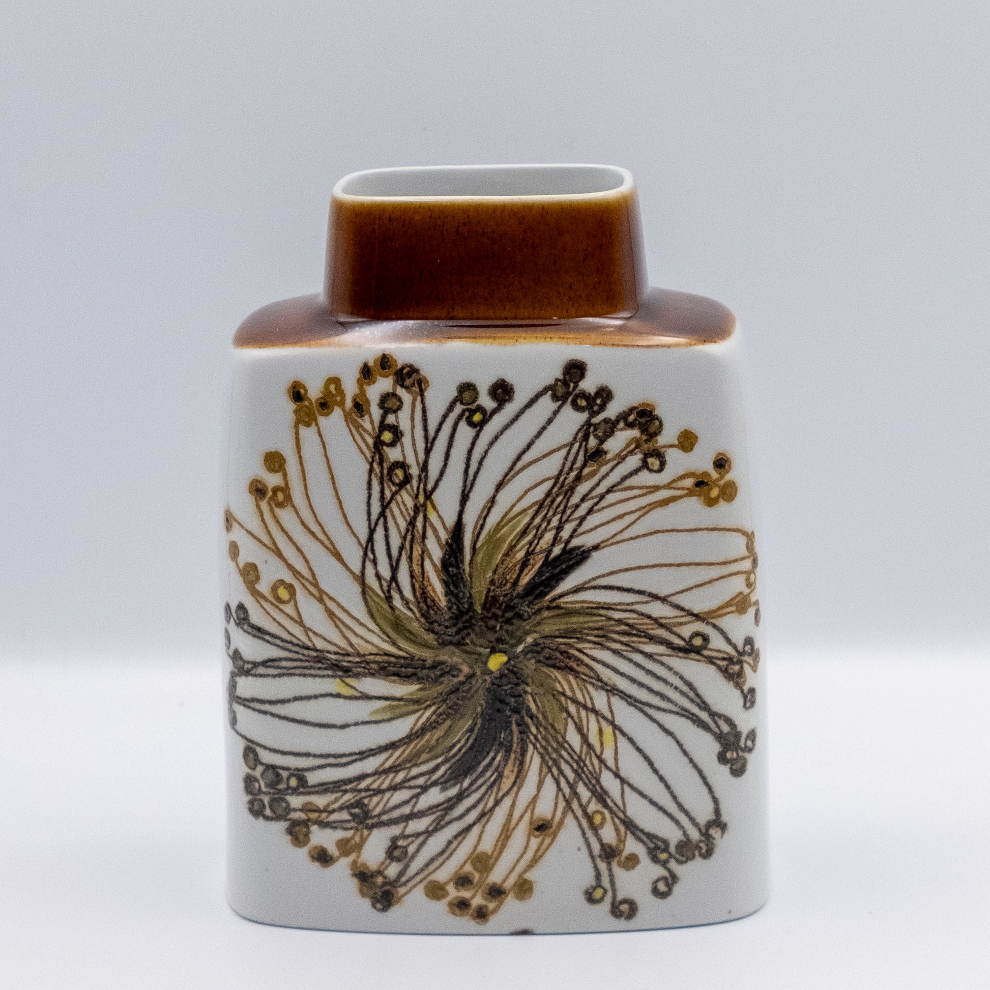ロイヤルコペンハーゲン「バッカ（Baca）」シリーズのヴィンテージ花瓶。エレン・マルマーによる放射状の花模様。白地にブラウンと黄色の色彩、キャラメル色のネックが特徴のスクエア型。マットな質感と緻密な描線が美しい北欧陶器。